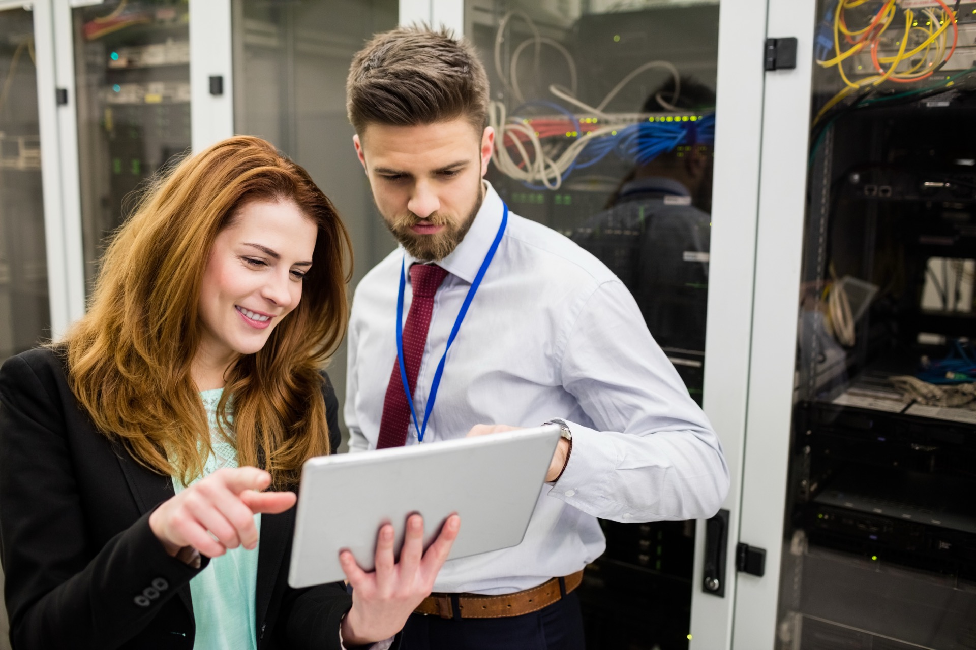Technicians using digital tablet while analyzing server